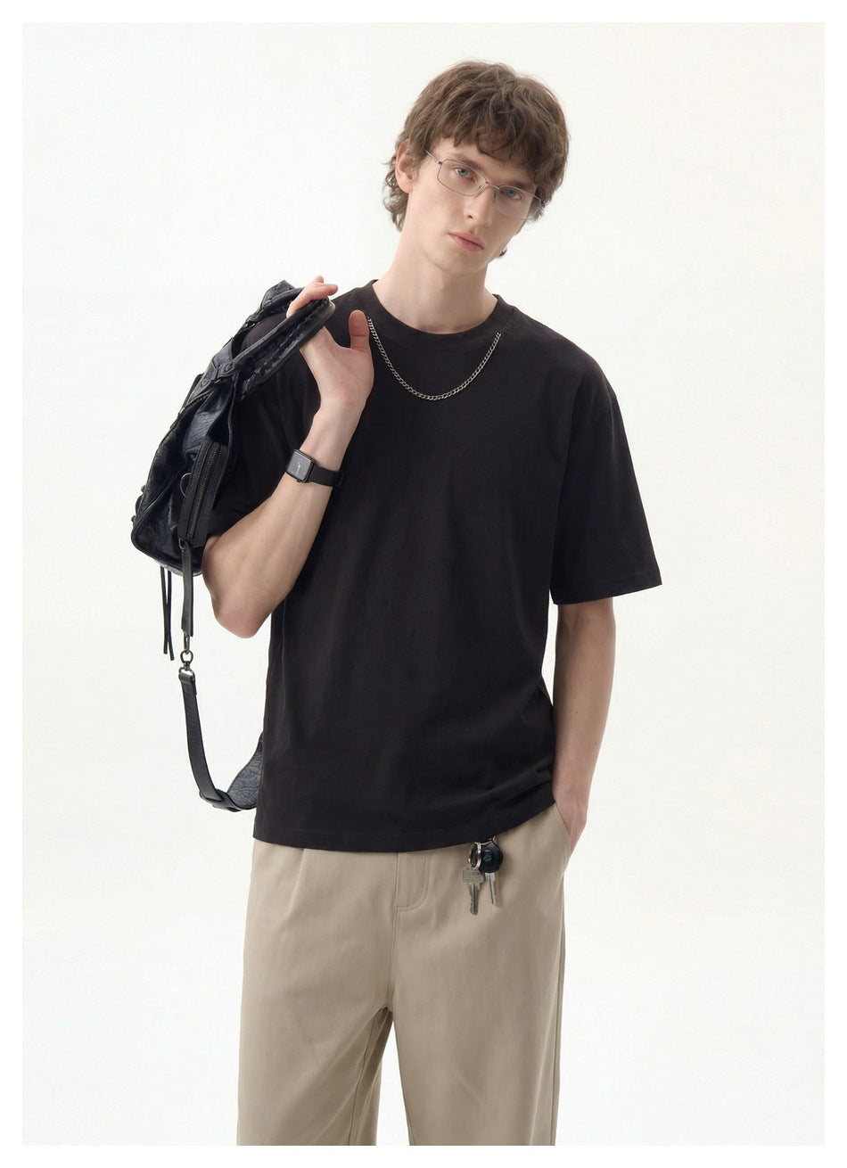 Closer front view of a model wearing a plain black crew-neck T-shirt.