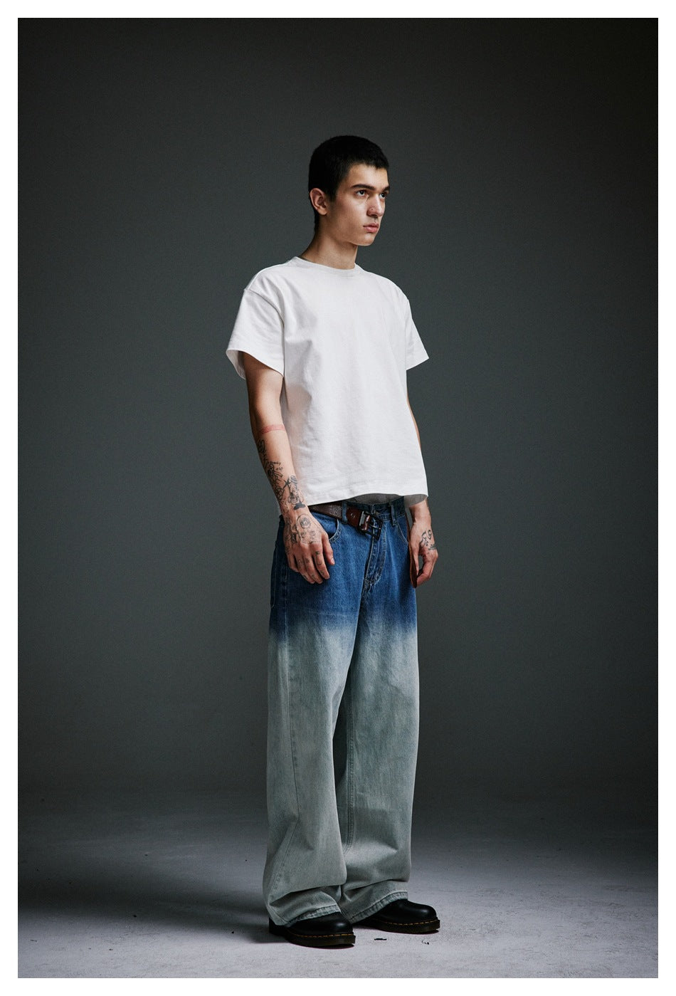 Model wearing a plain white short-sleeve T-shirt and very wide blue jeans with pale washed legs.