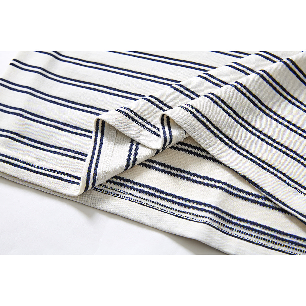 Close-up of the ivory and navy striped T-shirt's folded hem and stitching.