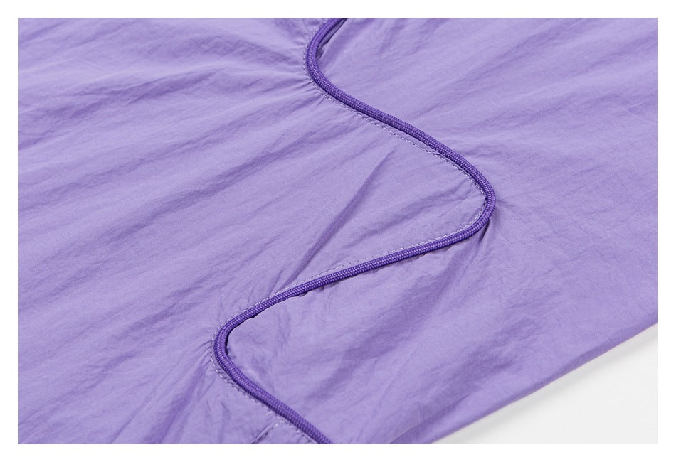 Close-up of a curved purple zipper set into lavender pants.