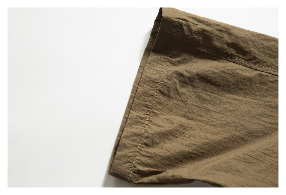 Close-up of a brown garment edge and seam against a white background.