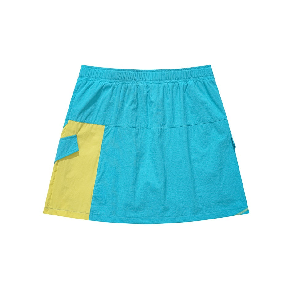 Front view of a turquoise A-line skirt with an elastic waistband and a contrasting yellow side panel and pocket flap.