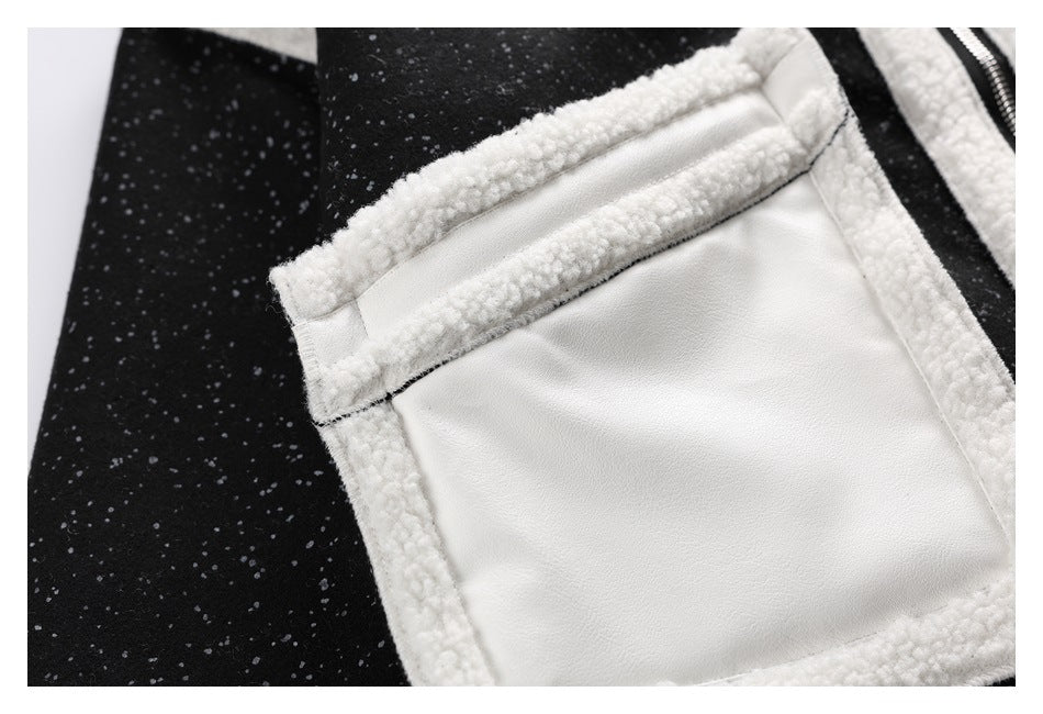 Close-up of a white-trimmed pocket on a black speckled jacket.