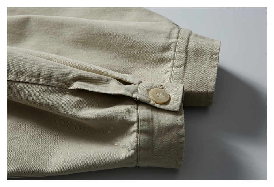 Close-up of a light khaki jacket sleeve cuff with an adjustable button tab.