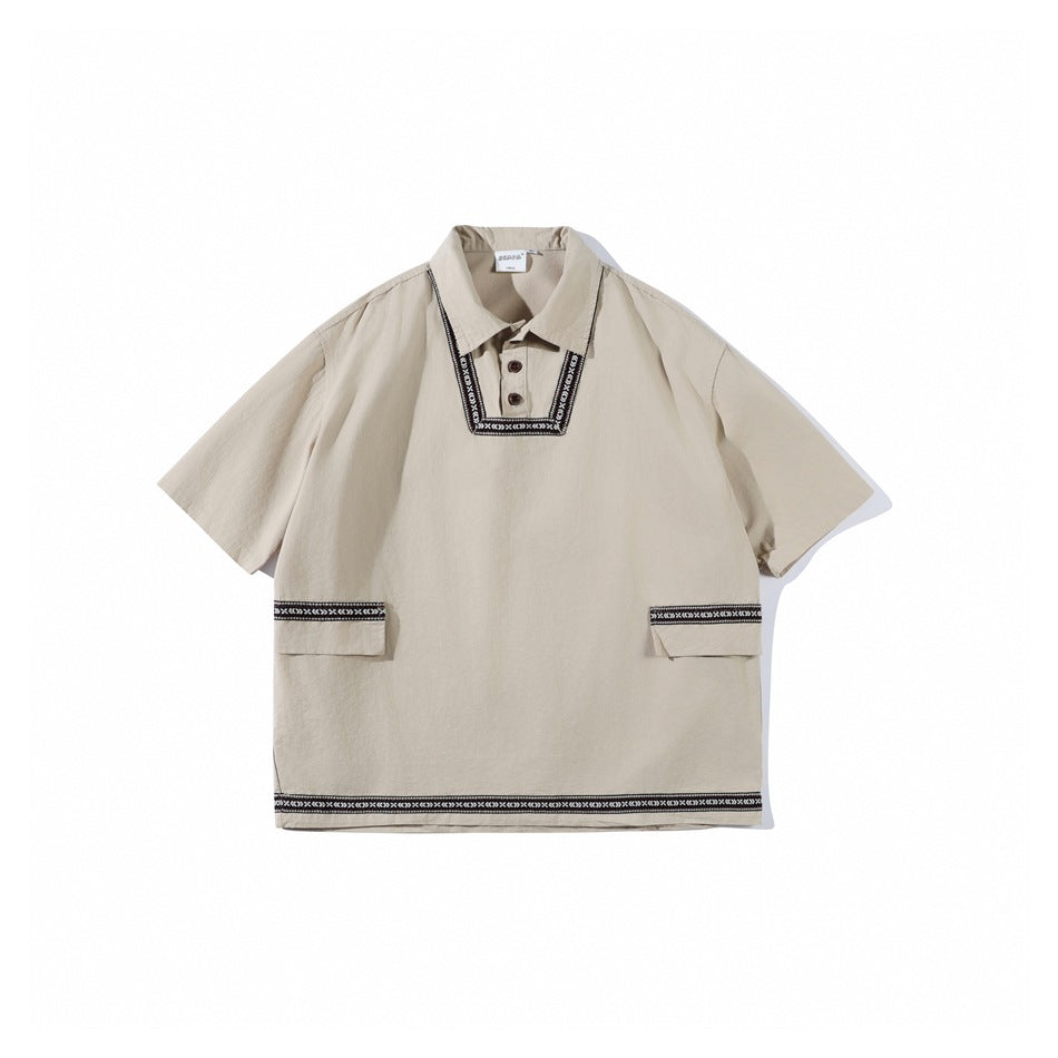 Apricot short-sleeve pullover shirt with collar, two buttons, black-and-white woven trim and two flap pockets, flat lay