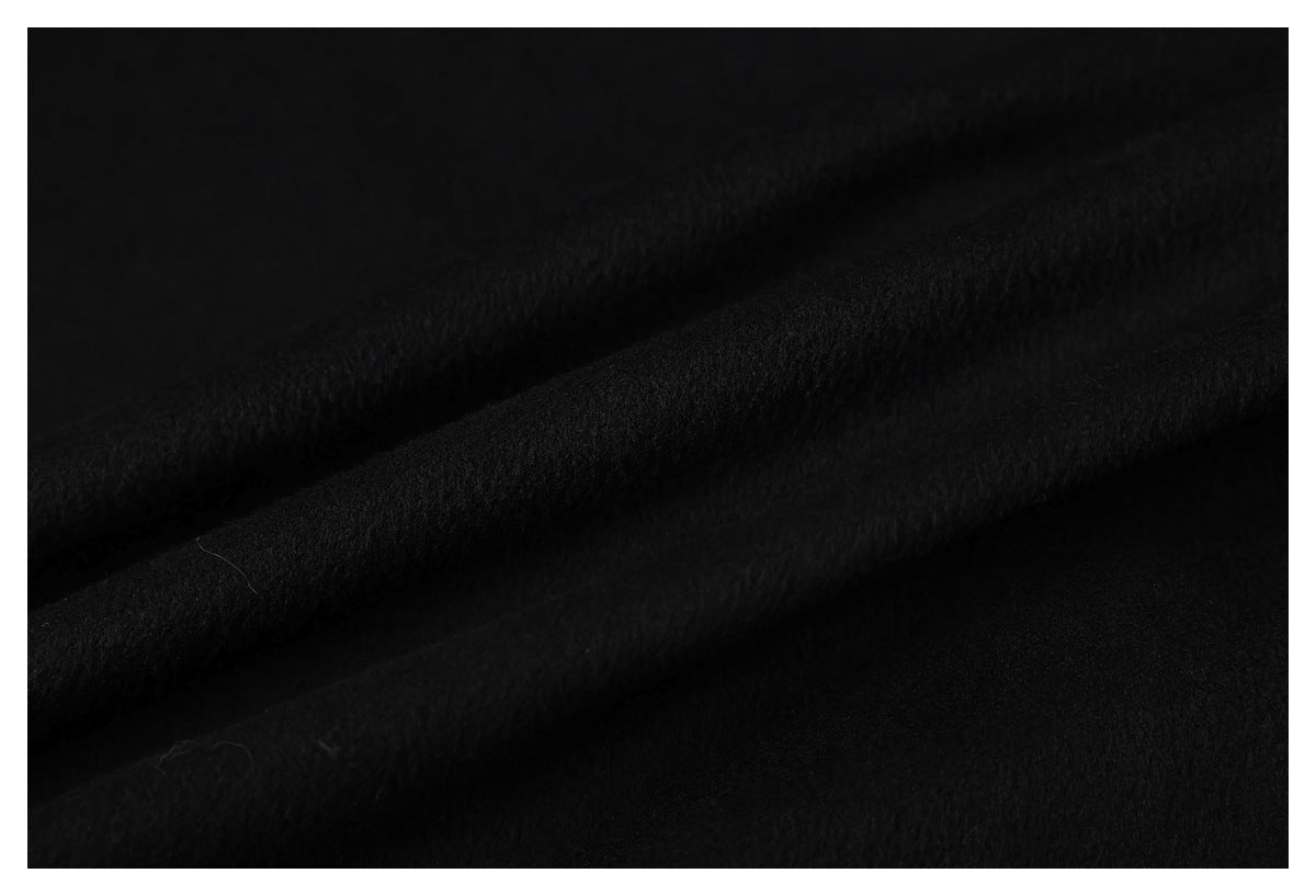Close-up of the black jacket's textured fabric folded into soft ridges.