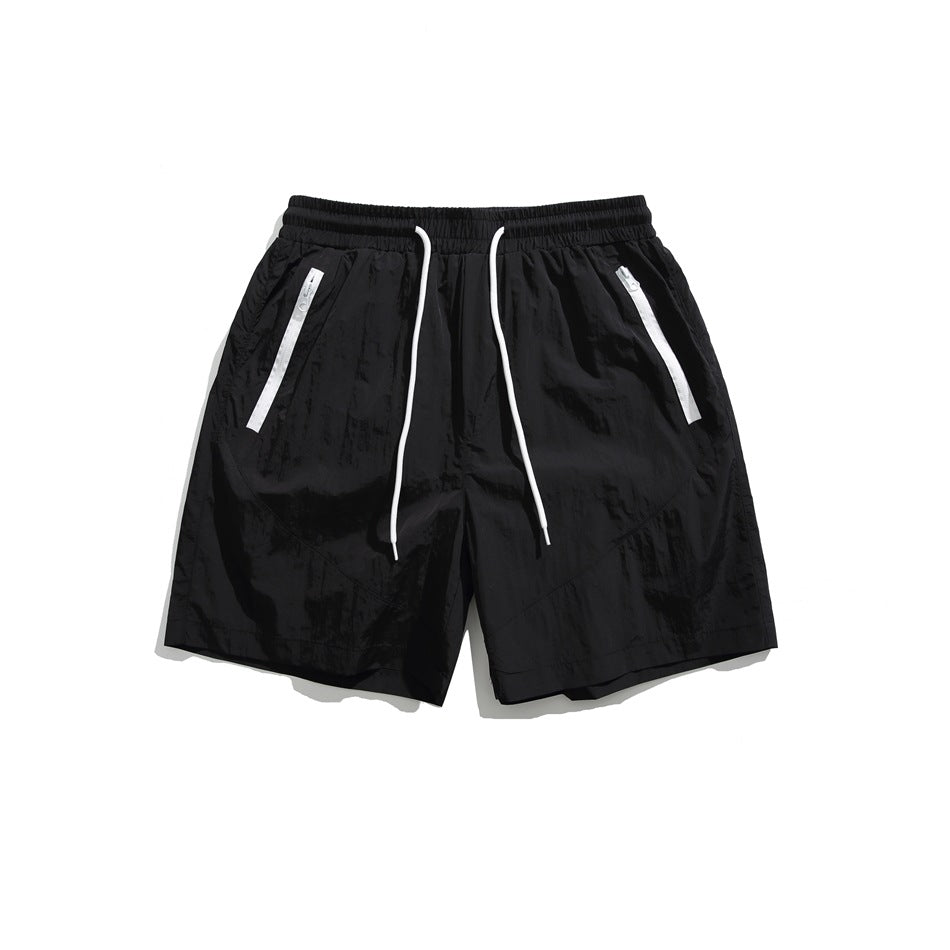 Black drawstring shorts with white zipper-tape pockets, flat lay front view