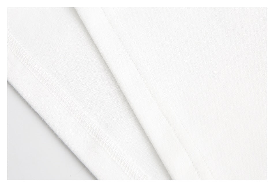 Close-up of white garment fabric showing an overlocked seam and a folded stitched edge.