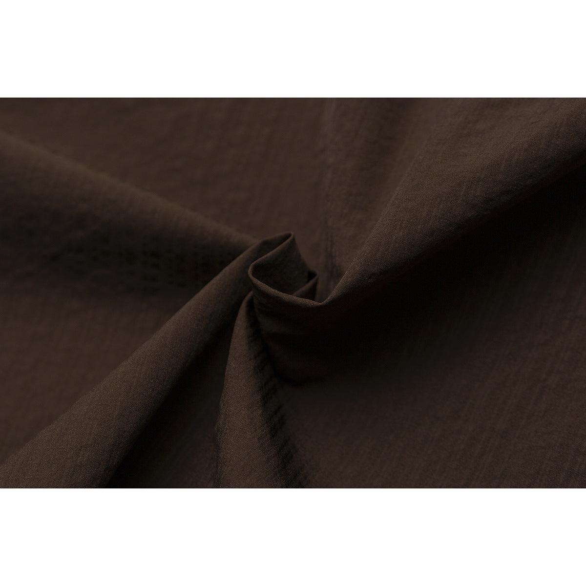 Close-up of dark brown shirt fabric folded to show its surface and drape.