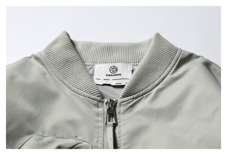 Close-up of a pale gray-green jacket collar, ribbed neckline, center zipper, and inside brand label.