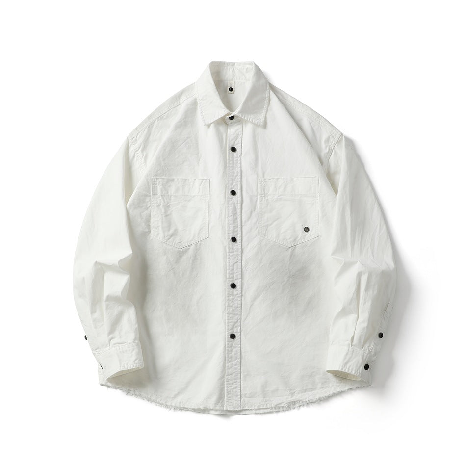 White long-sleeve button-front shirt with black buttons, two chest pockets and frayed hem, flat lay