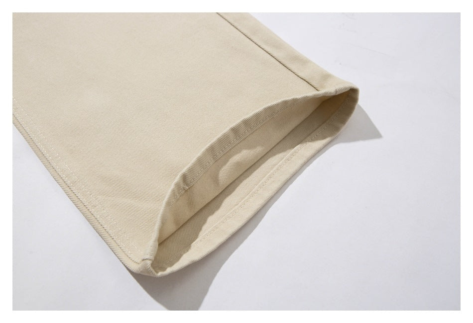 Close-up of the stitched hem on a beige pant leg.