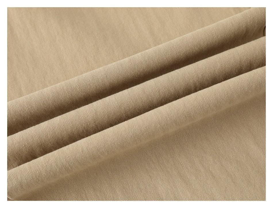 Close-up of tan fabric folded into ridges, showing a subtle herringbone weave.