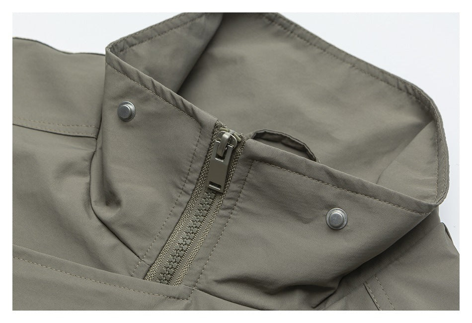 Close-up of an olive-gray garment collar showing a zipper and two metal snaps.