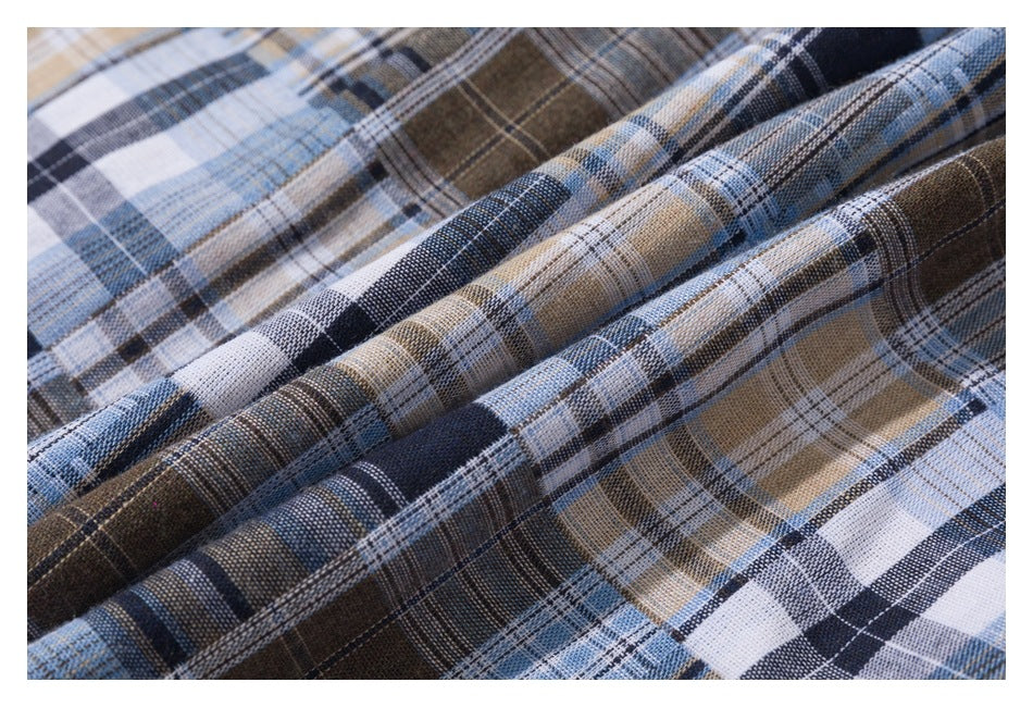 Close-up of blue, gray, cream, and brown plaid fabric gathered into soft folds.