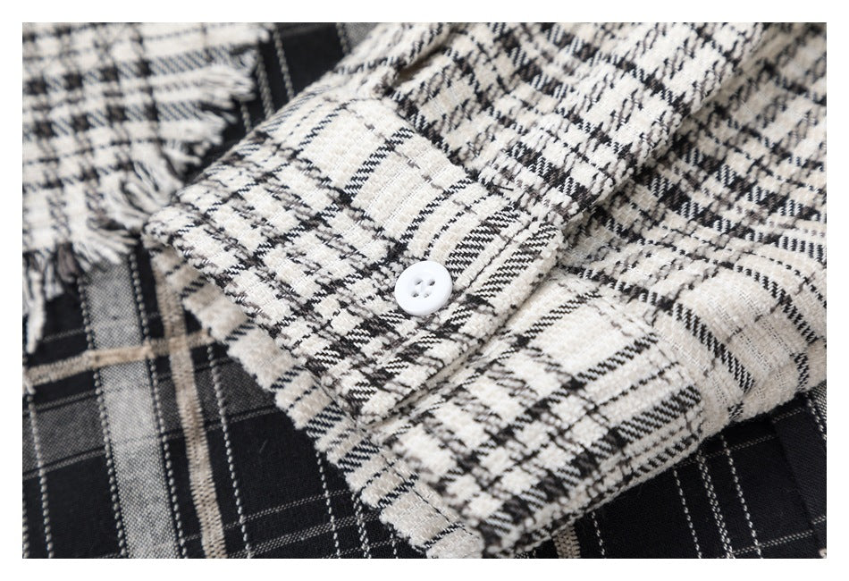 Close-up of the plaid shirt cuff with a white button and frayed edges.