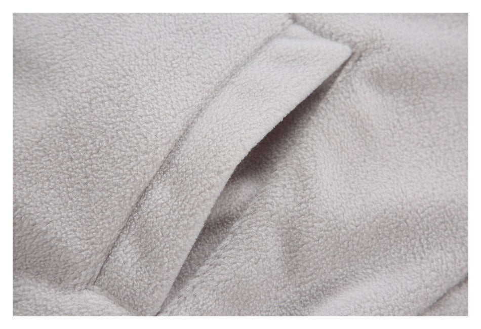 Close-up of pale gray fuzzy fabric with a folded seam or flap.