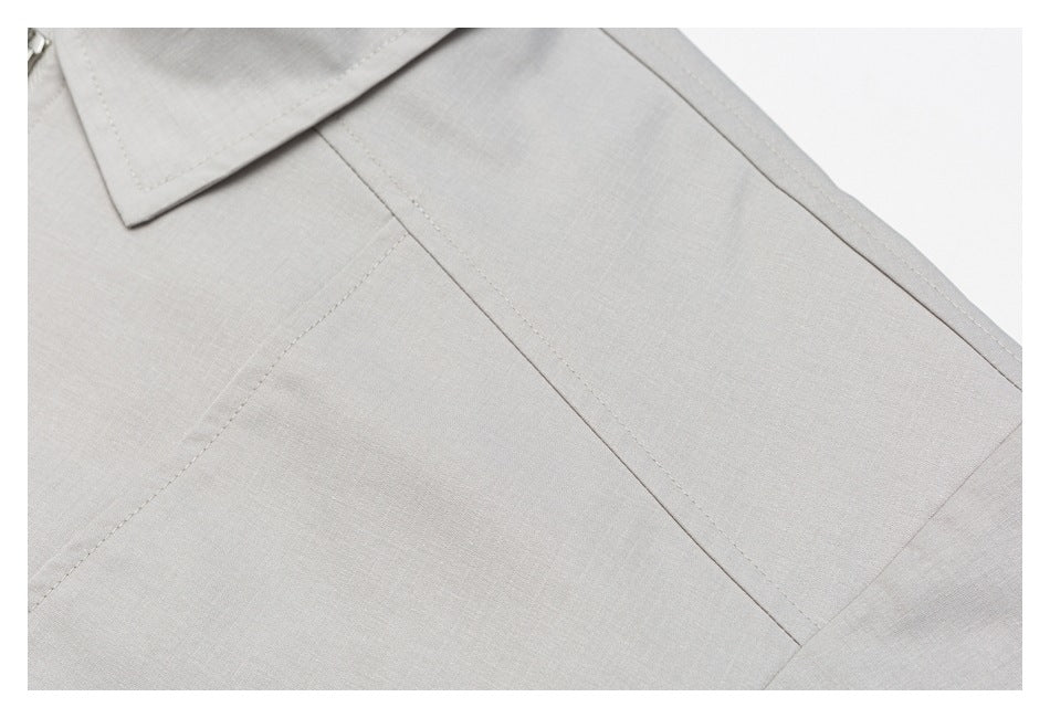 Close-up of stitched panel seams on the light gray jacket.