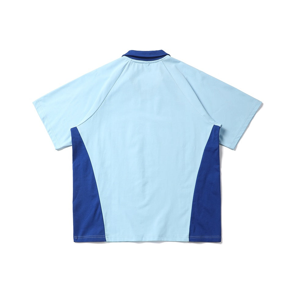 Back view of a short-sleeve color-block shirt with a pale blue body and royal blue collar and side panels.
