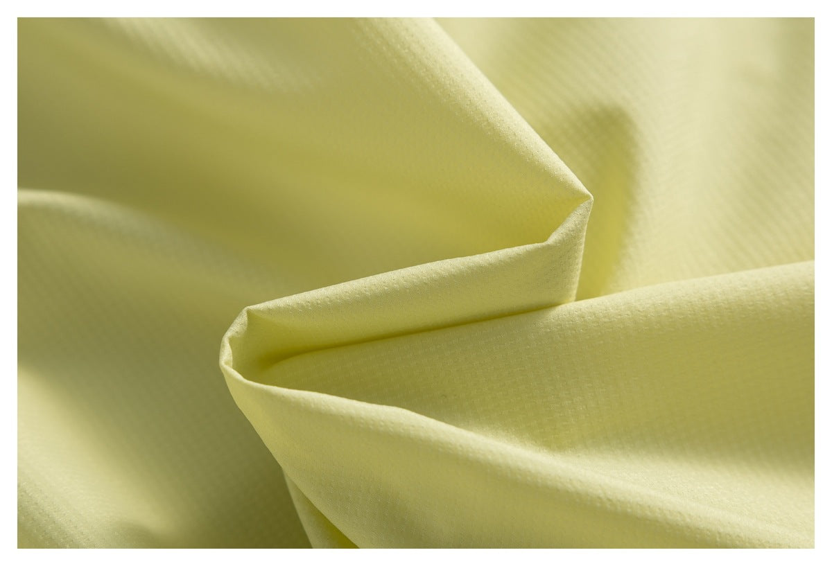 Close-up showing the fine texture and drape of pale yellow garment fabric.