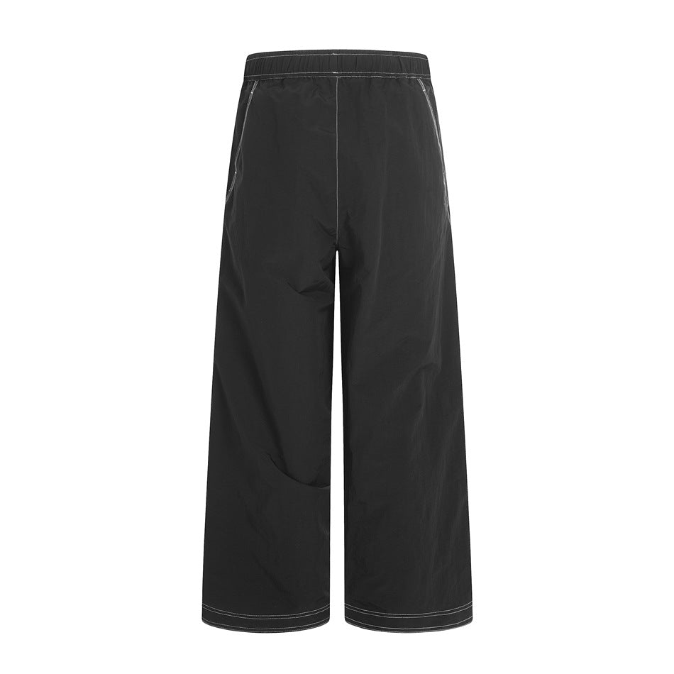 Back view of black wide-leg pants with an elastic waist and contrasting light stitching.