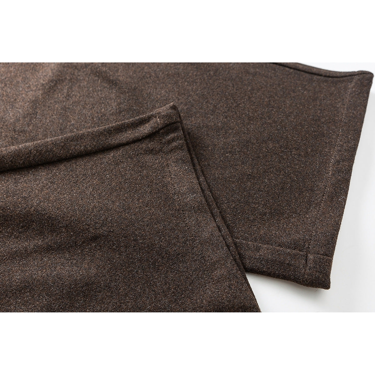 Close-up of brown pants fabric and stitched hem details.