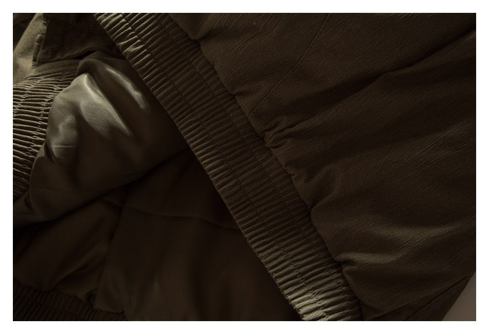 Close-up of dark olive-brown garment fabric with gathered ribbed trim and folded lining.