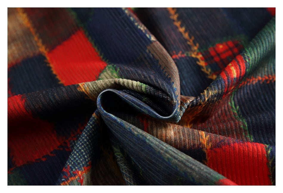 Close-up of folded multicolor patchwork fabric with ribbed texture and red, navy, green, and brown blocks.