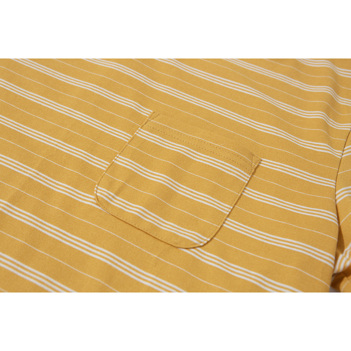 Close-up of a chest pocket on a mustard yellow T-shirt with thin white horizontal stripes.
