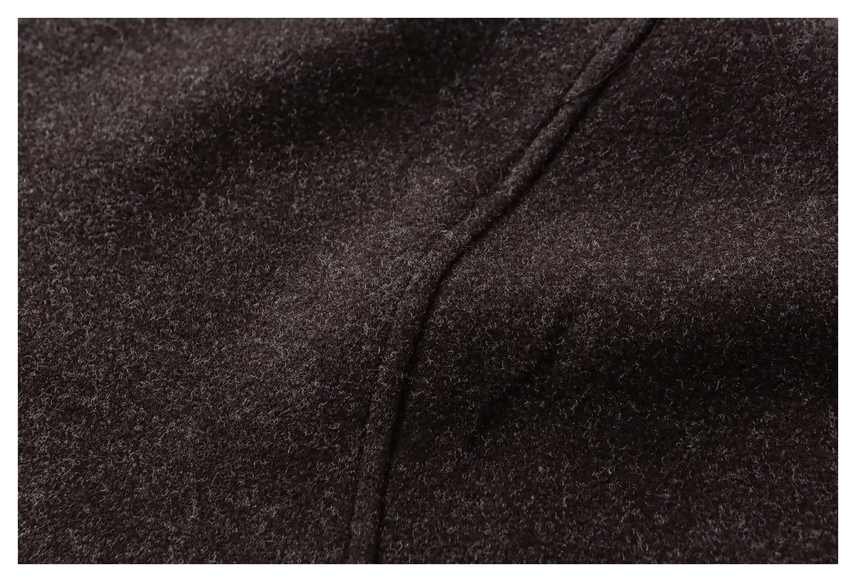 Macro view of the dark brown jacket's textured fabric and curved seam.