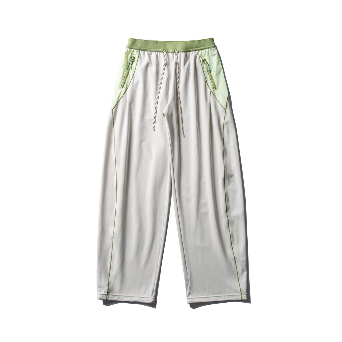 Off-white wide-leg pants with green ribbed waistband, light green side panels, zip pockets, drawstring and green piping