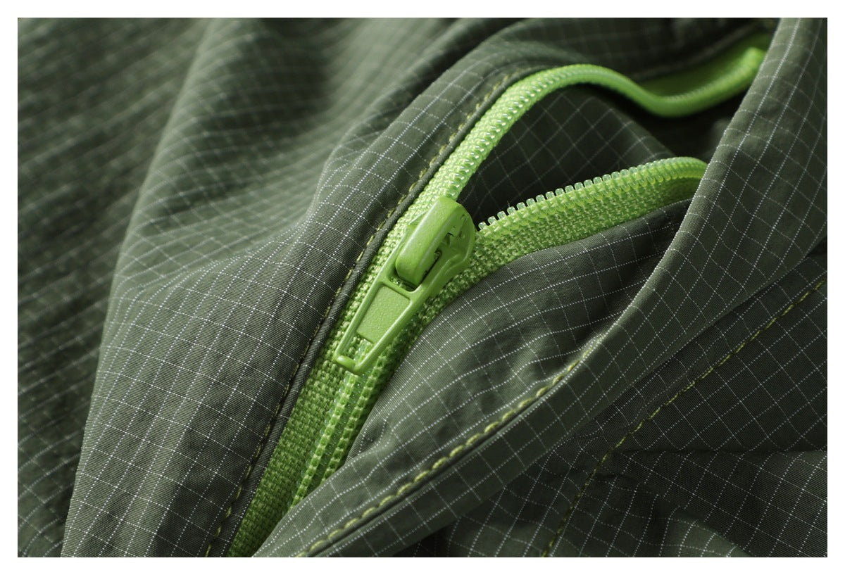 Close-up of a bright lime-green zipper and pull on olive-green grid-patterned fabric.