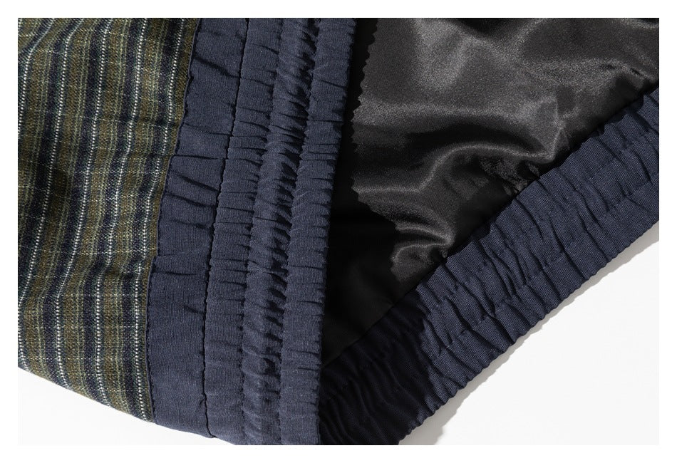Close-up of the jacket’s black lining and gathered navy hem beside the striped outer fabric.
