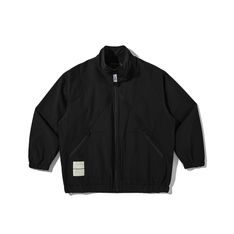 Black stand-collar zip jacket flat lay with diagonal chest trim, angled zip pockets, elastic cuffs and cream label