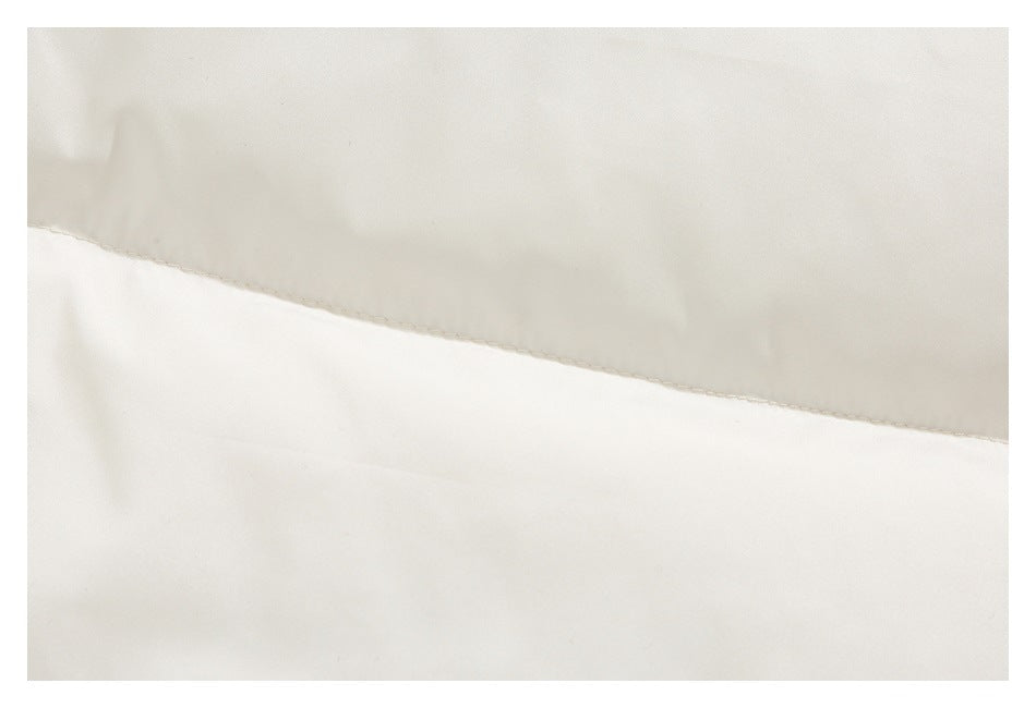 Close-up of cream jacket fabric and a curved stitched seam.