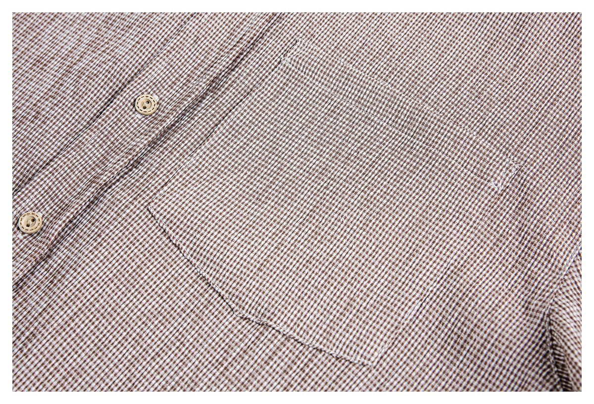 Close-up of a brown-and-white checked shirt's button placket and chest pocket.