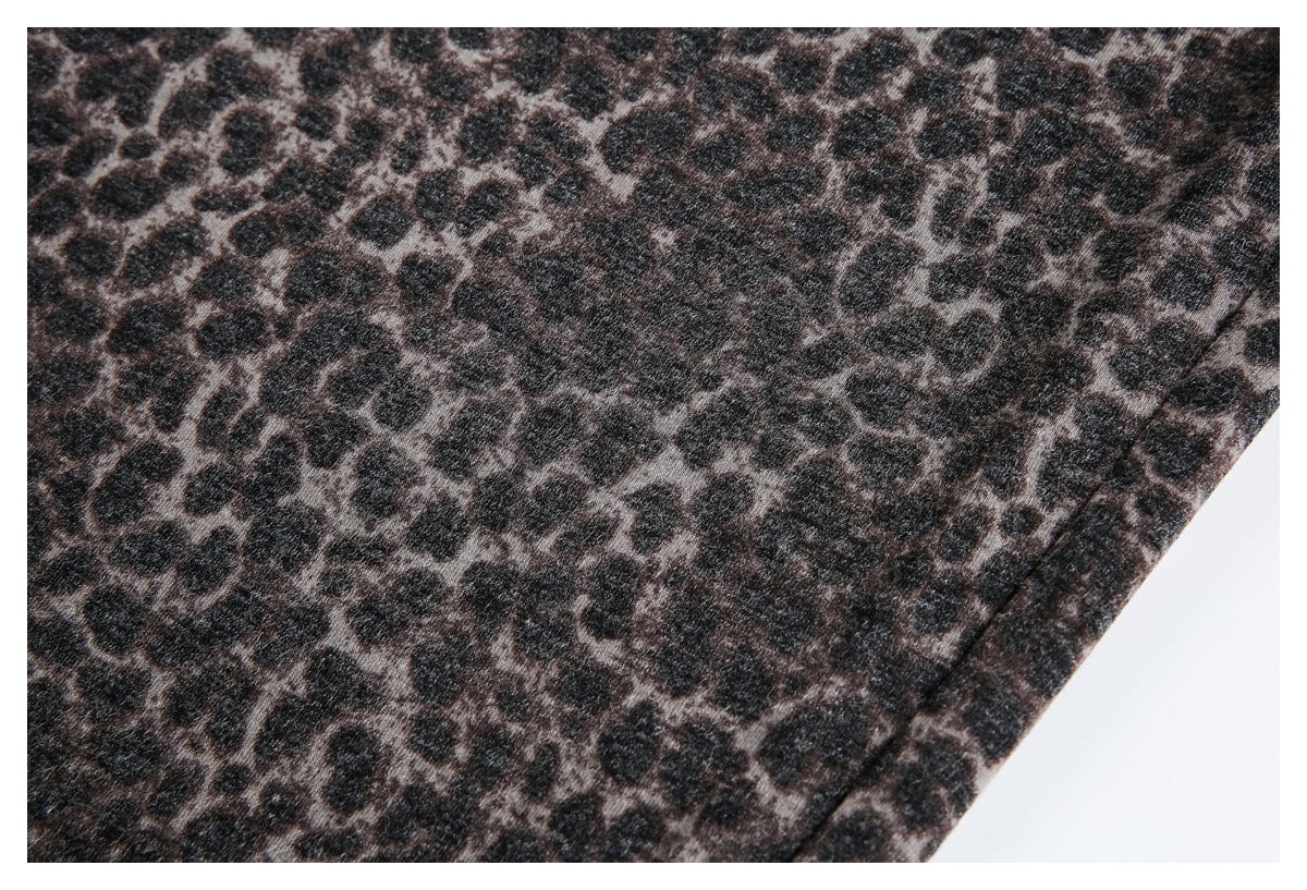 Close-up of dark brown and black leopard-print fabric with irregular spots.