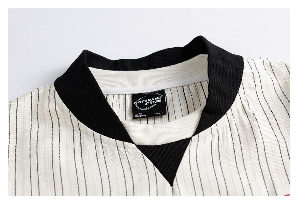 Close-up of an ivory pinstriped garment neckline with a black ribbed collar and inner brand label.