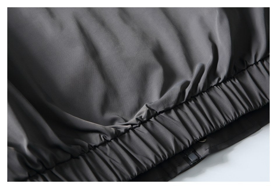Close-up of a gathered elasticized edge on a dark gray garment.