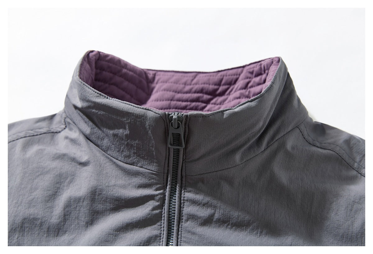 Close-up of a charcoal gray jacket collar with purple quilted lining and a centered front zipper.