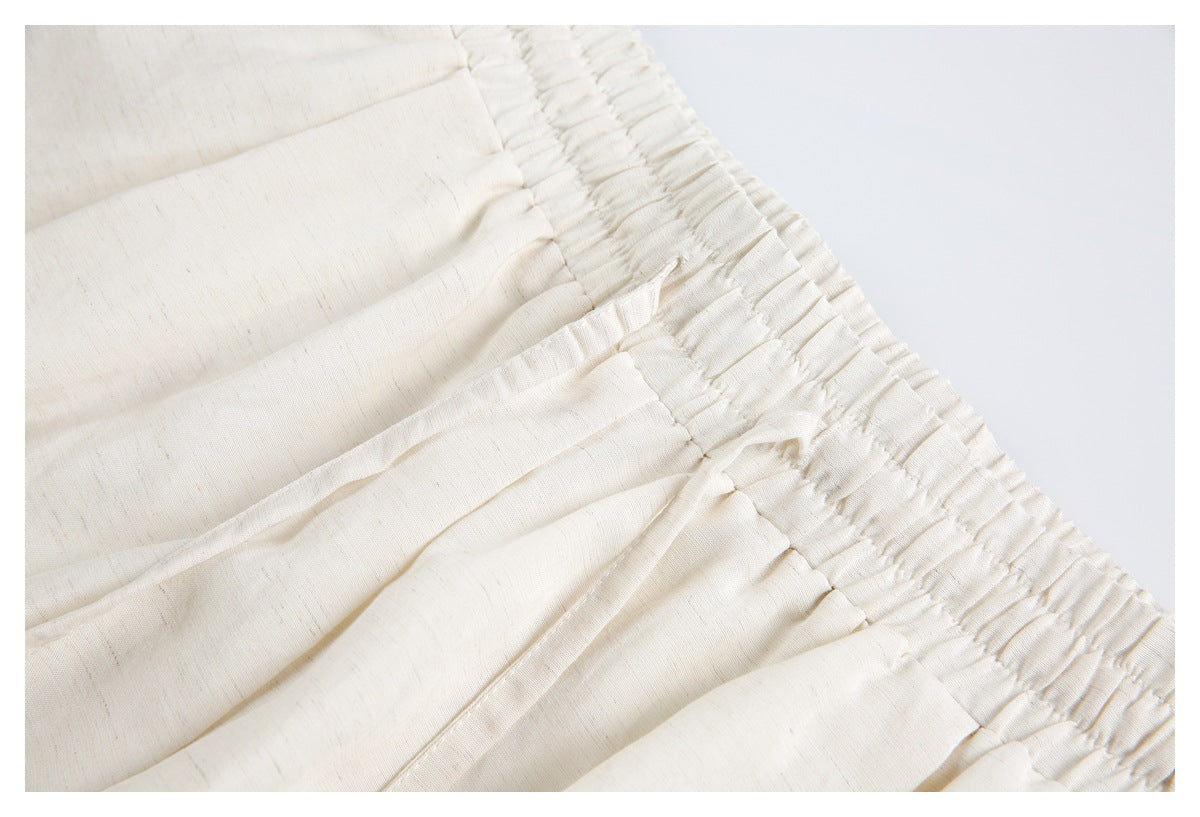 Close-up of the ivory shorts' elastic waistband, pleats, and drawstring.