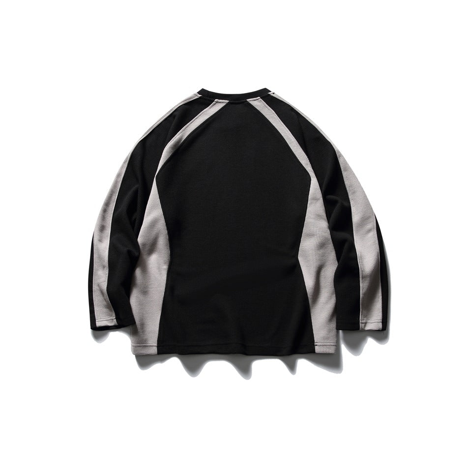Back view of a black long-sleeve top with light gray raglan panels and a plain black back.