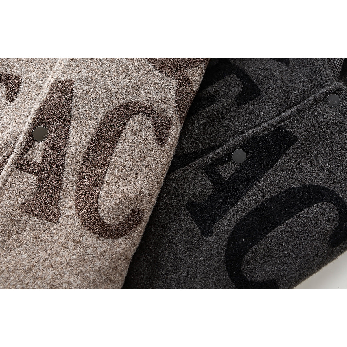 Close-up of taupe and charcoal jackets with large dark lettering, motifs and snap buttons.