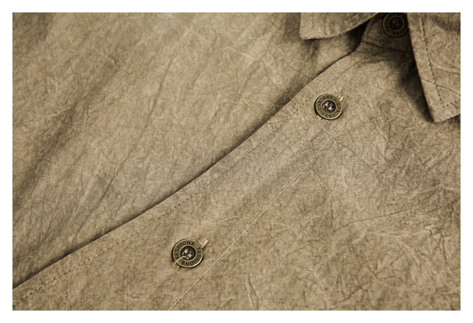 Close-up of the khaki-brown shirt's button placket, stitching, and round buttons.