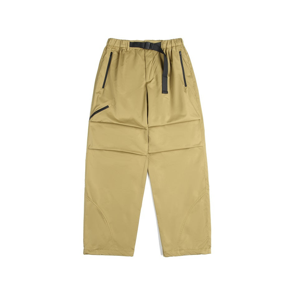 Yellow khaki wide-leg pants with black belt, zippered pockets, knee pleats and curved lower-leg seams, flat lay