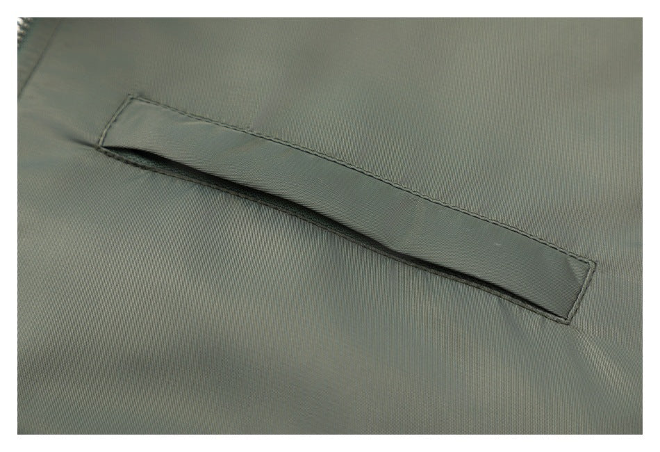 Close-up of a narrow welt pocket on olive-green jacket fabric.