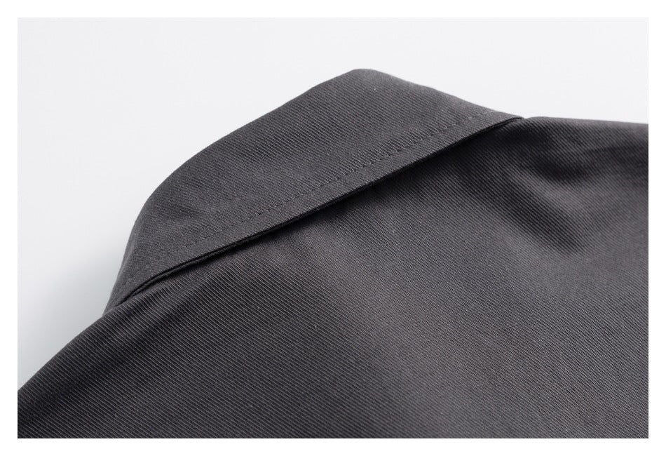 Close-up of the pointed collar and fine ribbed texture of a dark charcoal shirt.