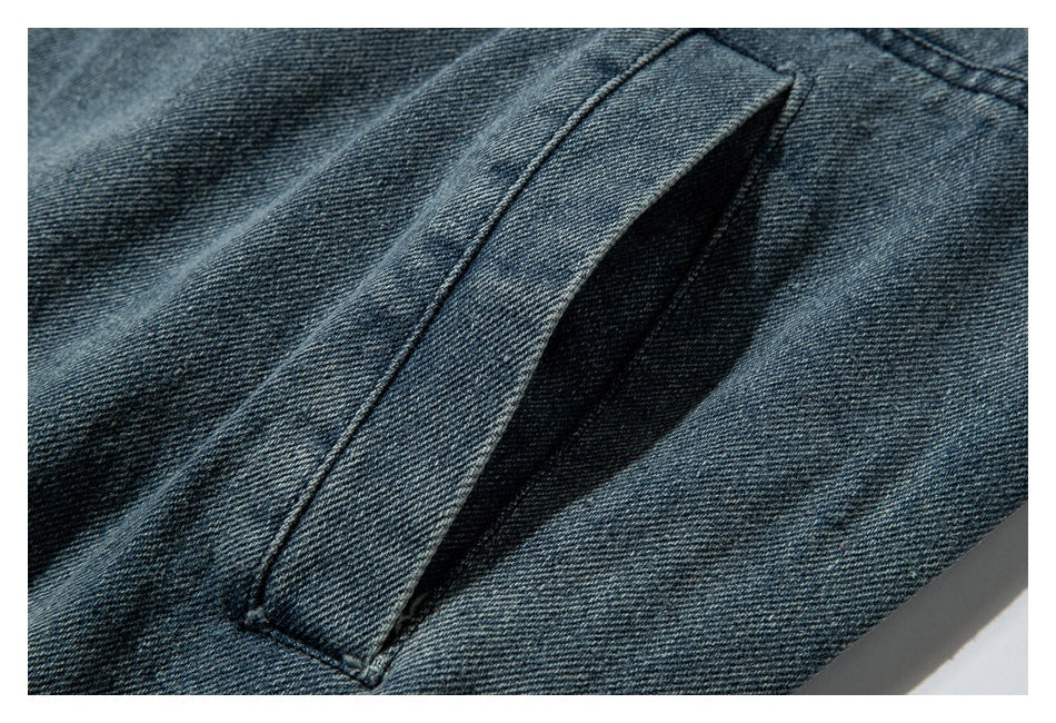 Close-up of a slanted pocket opening on a blue denim jacket.
