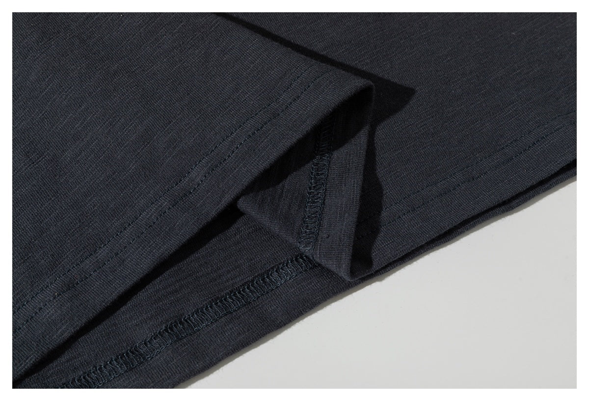 Close-up of the charcoal T-shirt's bottom hem and overlocked seam.