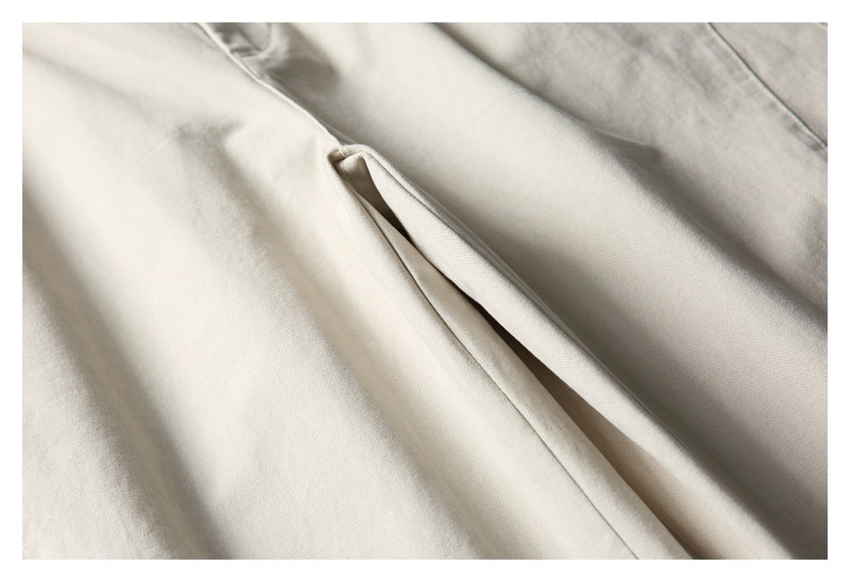 Close-up of a slanted pocket opening and stitching on light beige trousers.